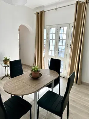 a dining room with a wooden table and chairs at K&K Apartments in Machico