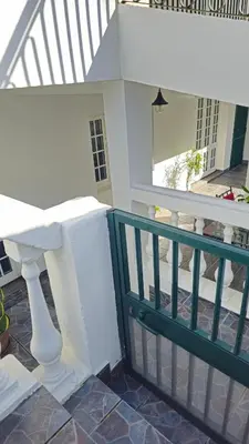 a porch with a white railing and a staircase at K&K Apartments in Machico