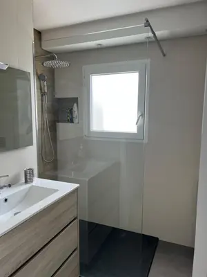 a bathroom with a sink and a shower with a window at Casa dos Anjos in Vila do Porto