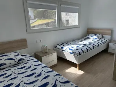 a bedroom with two beds and a window at Casa dos Anjos in Vila do Porto