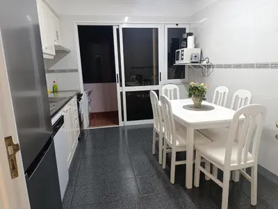 a kitchen with a white table and white chairs at Vista Mar Forum by Rentallido in Funchal