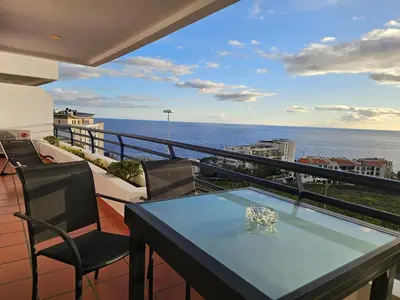 a balcony with a table and chairs and the ocean at Vista Mar Forum by Rentallido in Funchal