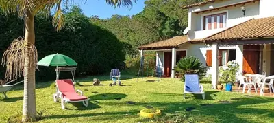 a yard with chairs and an umbrella and a house at Welcoming House in Santa Cruz with Garden of 269 m² in Santa Cruz