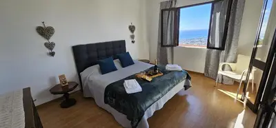 a bedroom with a large bed with blue pillows at Margarita House in Funchal
