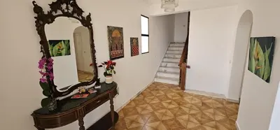 a hallway with a mirror on a table and stairs at Margarita House in Funchal