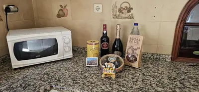 a counter with a microwave and some bottles of wine at Margarita House in Funchal