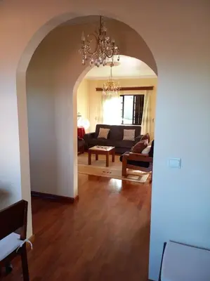 a living room with a couch and a chandelier at Casa Afonso a getaway apartment in Arco da Calheta