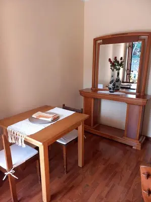 a room with a table and a mirror and a table and chairs at Casa Afonso a getaway apartment in Arco da Calheta