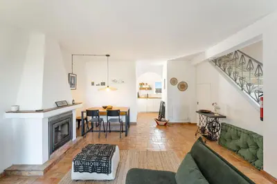 a living room with a green couch and a fireplace at Casa Matea in Figueira