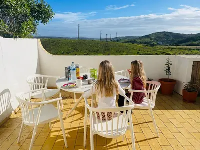 two little girls sitting at a table on a patio at Casa Matea in Figueira