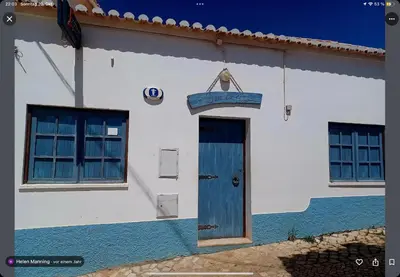 a white building with a blue door and windows at Casa Matea in Figueira