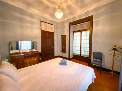 a bedroom with a bed and a desk and a chair at Casa da Avó Luísa in Funchal