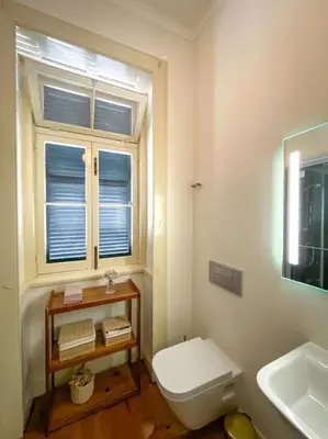 a bathroom with a toilet and a sink and a window at Casa da Avó Luísa in Funchal