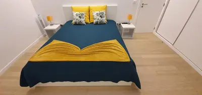 a bedroom with a bed with a yellow blanket at Sea&Sunrise Village in Caniço