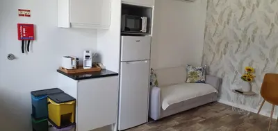 a small room with a refrigerator and a chair at Sea&Sunrise Village in Caniço