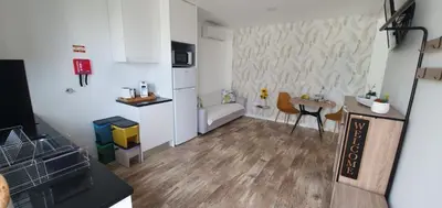 a small apartment with a kitchen and a table at Sea&Sunrise Village in Caniço