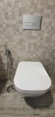 a white toilet in a bathroom with a wall at Sea&Sunrise Village in Caniço
