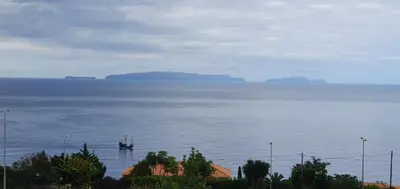 a boat in the middle of a large body of water at Sea&Sunrise Village in Caniço