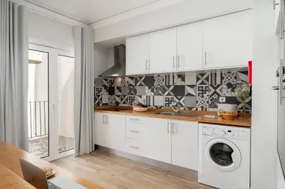 a kitchen with white cabinets and a washer and dryer at Loft Arrifes by An Island Apart in Funchal