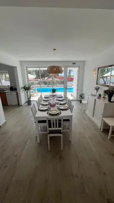 a white dining room with a table and chairs at Dad's Villa in Lagos