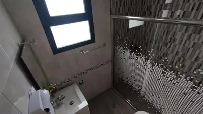 a bathroom with a shower and a sink and a window at Villa do Italiane in Estreito da Calheta