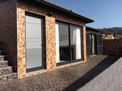 a extension to a house with sliding glass doors at Villa do Italiane in Estreito da Calheta