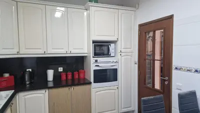 a kitchen with white cabinets and a microwave at Vila Boa Nova Funchal in Funchal
