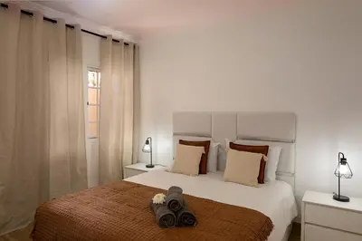 a bedroom with a bed with two pairs of shoes on it at Franco's House, mar e serra in Estreito da Calheta