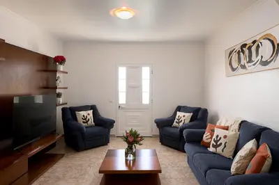 a living room with two blue couches and a tv at Franco's House, mar e serra in Estreito da Calheta