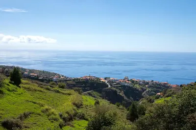 a town on a hill overlooking the ocean at Franco's House, mar e serra in Estreito da Calheta