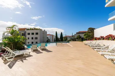 a row of lounge chairs on a patio with a pool at Eden Loft by Madeira Dream Stays in Funchal
