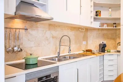 a kitchen with white cabinets and a sink at Cantinho dos Ilhéus in Funchal