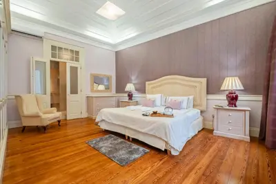 a bedroom with a large bed and a chair at Villa Diniz by Madeira Dream Stays in Funchal