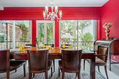 a dining room with red walls and a wooden table and chairs at Villa Diniz by Madeira Dream Stays in Funchal