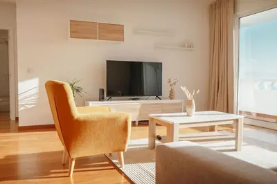 a dining room table with white chairs around it at Cristo Rei Ocean View in Caniço