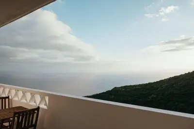 a bedroom with a large bed with a brown blanket at Cristo Rei Ocean View in Caniço