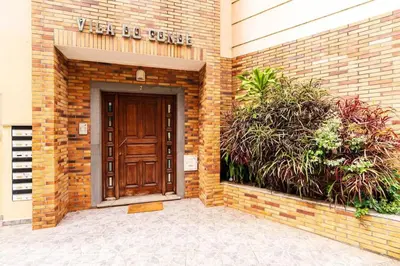 a brick building with a brown door and plants at Vila do Conde Nº3 in Ribeira Brava