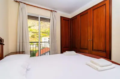 a bedroom with a large white bed and a window at Vila do Conde Nº3 in Ribeira Brava