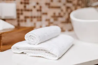 a stack of towels sitting on a counter in a bathroom at Mea Suna in Arco da Calheta