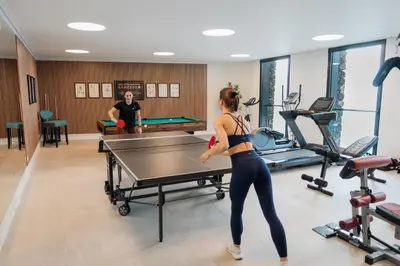 a woman playing ping pong in a gym at Mea Suna in Arco da Calheta