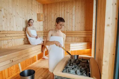 two women in a sauna cooking food in a stove at Mea Suna in Arco da Calheta