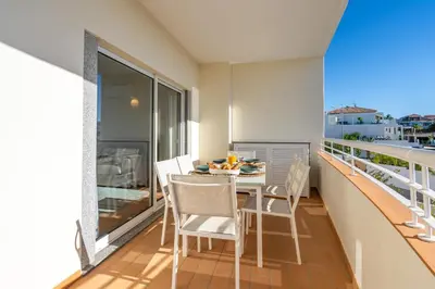 a balcony with a table and chairs on a balcony at Host Wise - Bright & Stylish Lagos Flat with Pool in Lagos