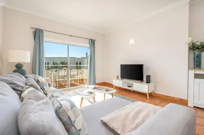 a living room with a couch and a tv at Host Wise - Bright & Stylish Lagos Flat with Pool in Lagos