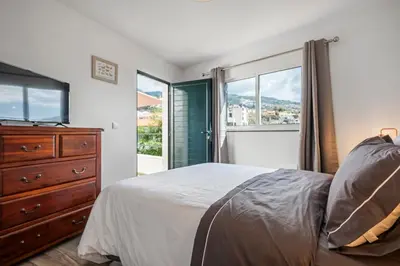 a bedroom with a bed and a dresser and a window at Betty's Villa by ALMA Holiday Rentals in Funchal