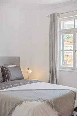 a white bedroom with a bed and a window at Betty's Villa by ALMA Holiday Rentals in Funchal