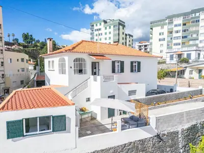 a white house with an orange roof at Betty's Villa by ALMA Holiday Rentals in Funchal