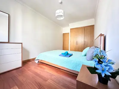a bedroom with a bed and a vase of flowers on a table at Rooms for Rent Residence Funchal in Funchal
