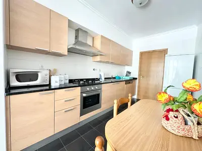 a kitchen with a table with a vase of flowers on it at Rooms for Rent Residence Funchal in Funchal