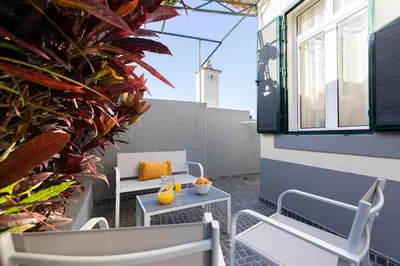 an outdoor patio with chairs and tables and plants at Casa da Jackie by Rent-a-key in Funchal