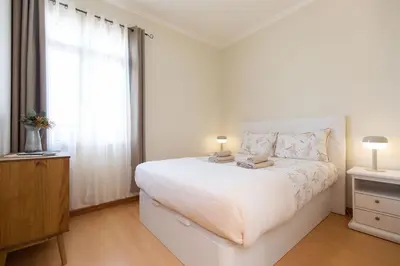 a white bedroom with a large bed and a window at Casa da Jackie by Rent-a-key in Funchal